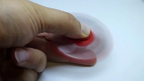 Bright red fidget finger spinner in hand on white background Stock Footage 78240727