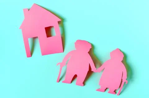 Bright red figures of two elderly people and a house on a colored background. Stock Photos