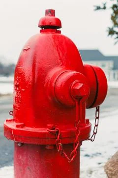 Bright red fire hydrant stands alone on a snowy street in a neighborhood du.. Stock Photos