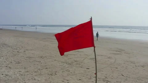 A bright red flag placed on the beach as a warning for the dangerous currents Video stock 146756018