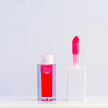 Bright Red Lip Gloss Opened on a White Minimalistic Background Foto stock