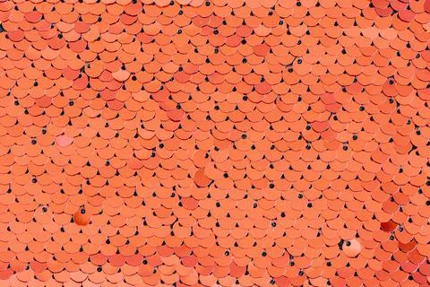 Bright red-orange sequins folded in the form of scales. Textured background. Stock Photos