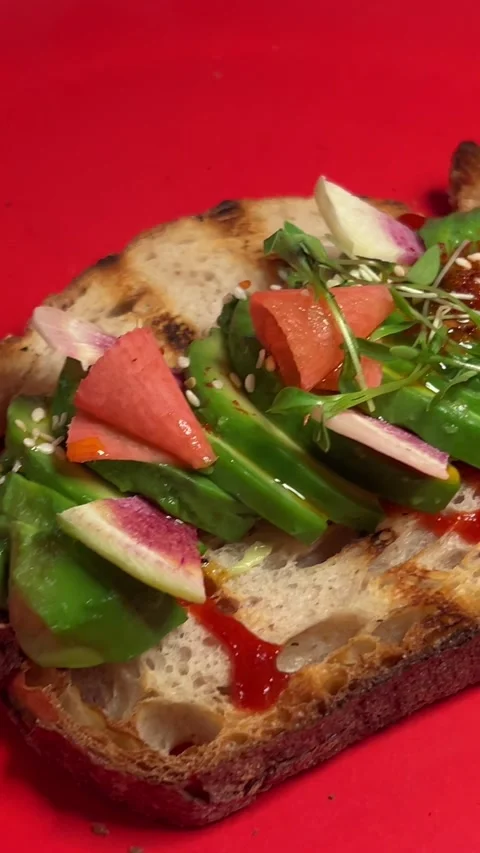 On a bright red plate avocado with baked lime Healthy food. Bread toast with Stock Footage 294529413