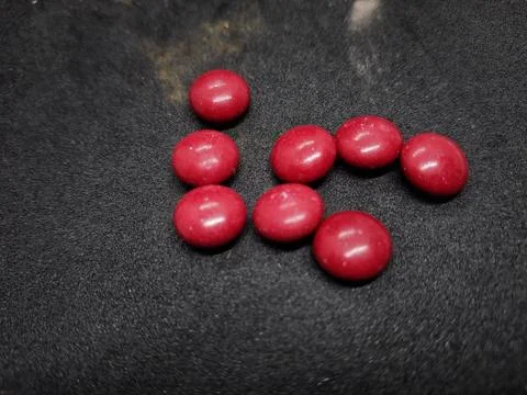 Bright red, round tablets often feature a smooth, glossy finish. Stock Photos