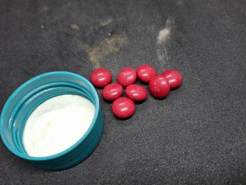 Bright red, round tablets often feature a smooth, glossy finish. Stock Photos