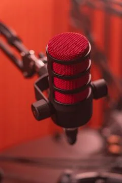 A bright red studio microphone closeup with a black body mounted on pantogr.. Stock Photos