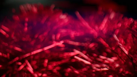 Bright red tinsel on the dark background. Christmas decoration in the form of Stock Footage 165948524