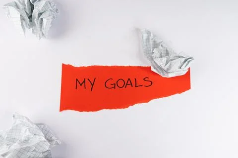 Bright red torn paper scrap displays handwritten my goals text surrounded b.. 스톡 사진
