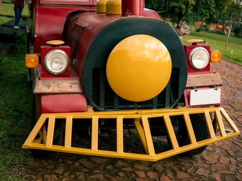 Bright red toy train with large yellow front dominates the scene Foto stock