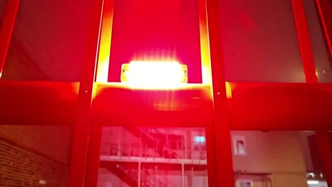 Bright red warning light mounted on metal structure at night Stock Footage 300299683