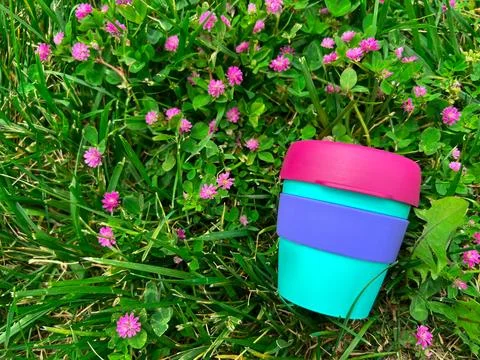 Bright reusable plastic beverage mug on the grass Stock Photos