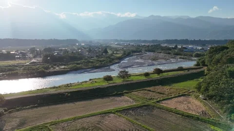 Bright River Bend and Fields Below Blue Hazy Mountains 動画素材 347930251