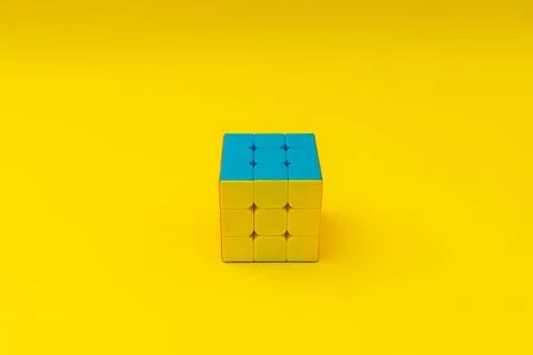 Bright rubik's cube on yellow background, colorful photo Stock Photos