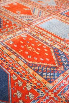 Bright rug with detailed patterns in a warm setting Stock Photos