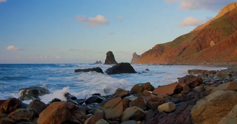 Bright sea sunset. The waves crash into the rock, lit by the warm sunset Stock Footage 200634668