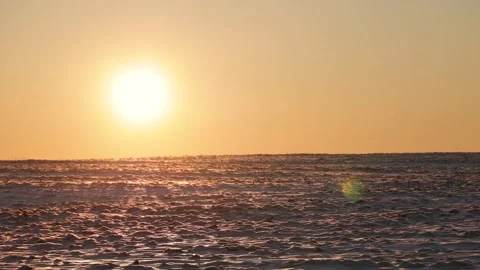 Bright setting sun over snow field at sunset, close up Stock Footage 303336641