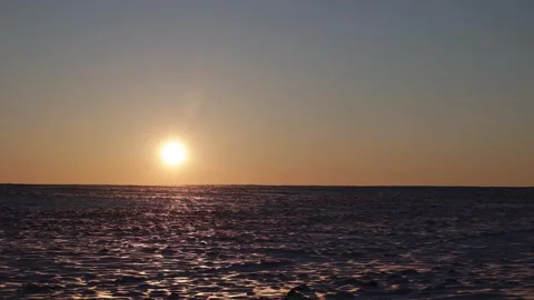 Bright setting sun over snow field at sunset Stock Footage 303336647