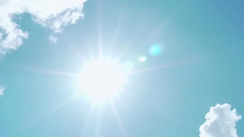 Bright Shining Sun with Rays and Glare in the Blue Sky, White Clouds Passing Thr Video stock 160265289