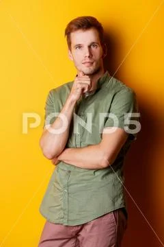 A bright shot of a man in a t-shirt. Yellow background. Fashion concept. Stock Photos