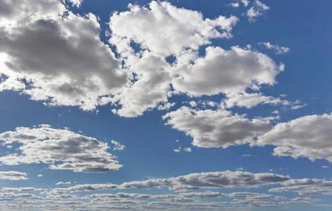 Bright sky background with few small clouds, strong sun shines through Stock Photos