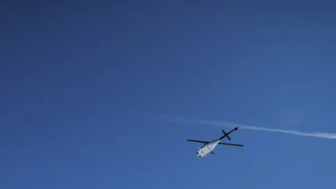 Bright sky features helicopter silhouette spinning blades and distant peaks Stock-Footage 322808439