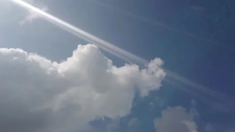 Bright sky with fluffy clouds and sun rays shining through. Stock Footage 329263400