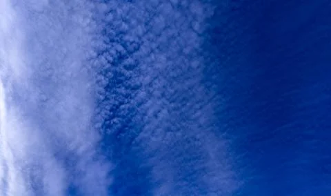 Bright sky with scattered clouds. Cloudy blue sky panorama. Soft white clouds in Stock Photos