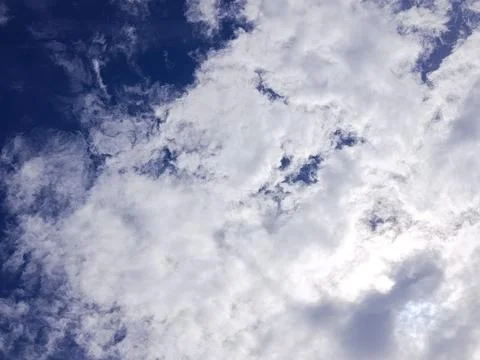 Bright sky with thick white clouds and soft sunlight filtering through Stock Photos