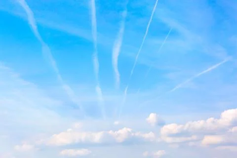 Bright sky with white clouds. Traces in different directions from airplanes Stock Photos