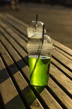 Bright soft drink in a transparent plastic cup Stock Photos