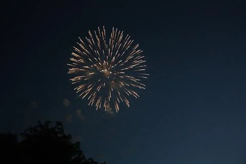 Bright spherical firework burst expanding in the deep night sky Фото