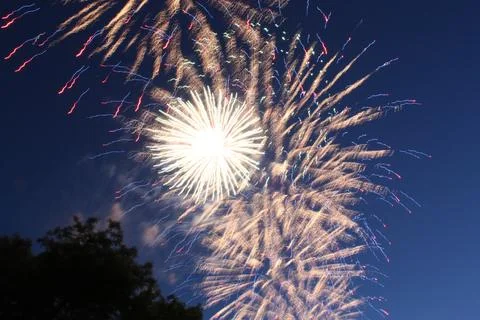 Bright spherical firework burst expanding in the deep night sky Фото