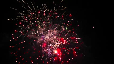 Bright splashes of fireworks flash on the black night sky green purple red .. Vidéo 250463338