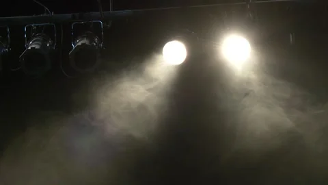 Bright spotlight shining through stage smoke Stock Footage 254323494