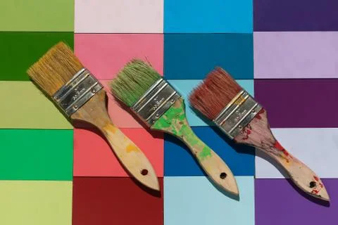 Bright spring colored tiled background with three angled paint brushes Stock Photos