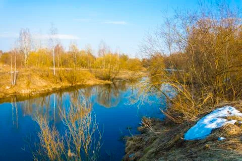 Bright spring landscape with a small river and blue sky. Stock Photos