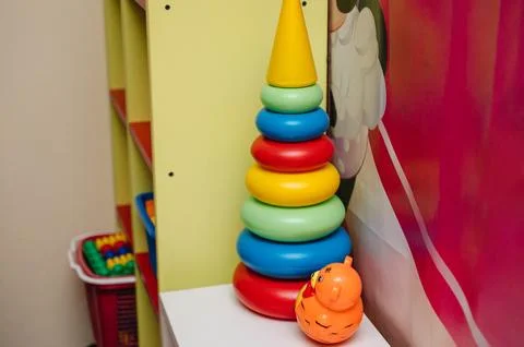 Bright stacking ring toy (pyramid) on the floor, essential for childhood de.. Stock Photos