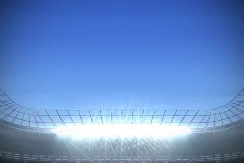 Bright stadium floodlight array is illuminating metal roof trusses and seating Foto stock