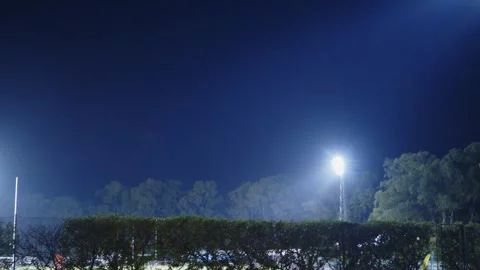 Bright stadium floodlight tower illuminating a sports field or park at nigh.. Stock Footage 335859067