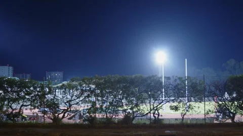 Bright stadium floodlight tower illuminating a sports field or park at nigh.. Stock Footage 335859073