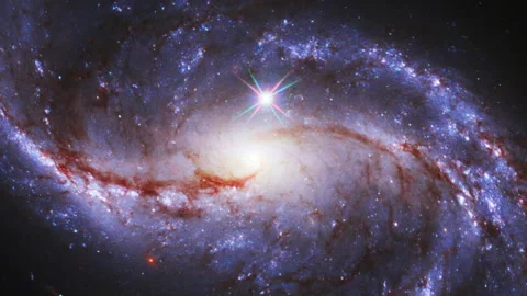 Bright star in outer space with spiralling galaxy background Video stock 154273329