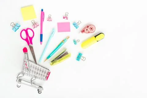 Bright stationery objects in mini supermarket cart on white background Stock Photos