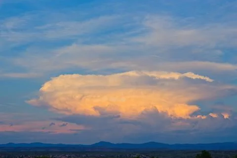 Bright storm cloud forming in a blue sky. Stock Photos