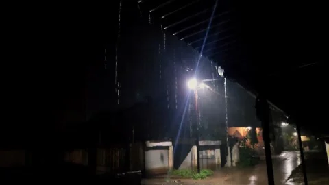 Bright street light illuminating a dark street during heavy rain at night, creat Stock Footage 346145551