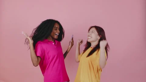 In a bright studio, two friends joyfully react to thrilling news on a mobile Video stock 286281866