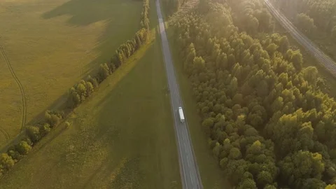 On a bright summer day, a drone flies over the highway along which cars and Stock Footage 169582482