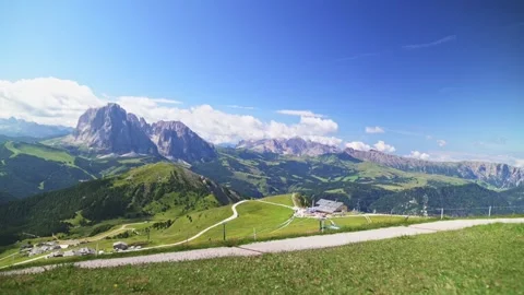 Bright summer view of the Seceda area in the Dolomites with winding road and Stock Footage 318666812