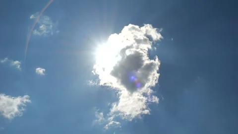 Bright sun appears from behind a small cumulus cloud Video stock 316090296