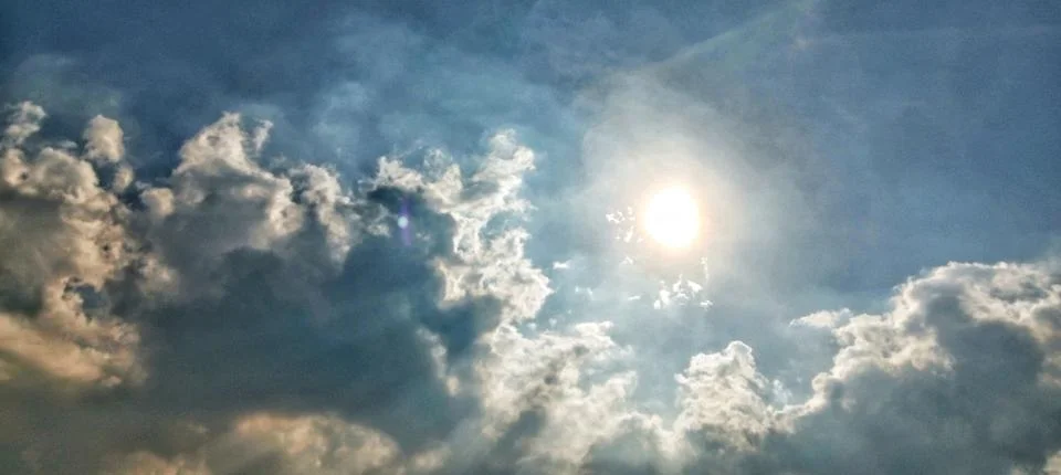 Bright sun behind clouds with diffused light for a concept of hope 스톡 사진
