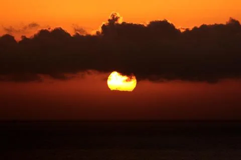 The bright sun between clouds during a nice sunset in Oia, Santorini Stock Photos